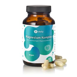 Braune Glasflasche mit Kapseln. Aufschrift: Magnesium Komplex, vegan, 60 Kapseln. Einige Kapseln liegen daneben.