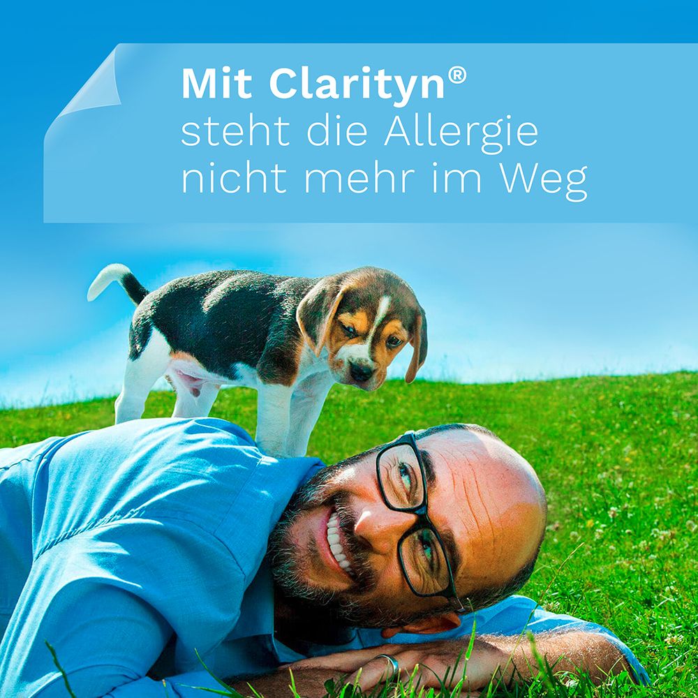 Mann liegt auf Wiese, Hund auf ihm. Text: Mit Claritn steht die Allergie nicht mehr im Weg.