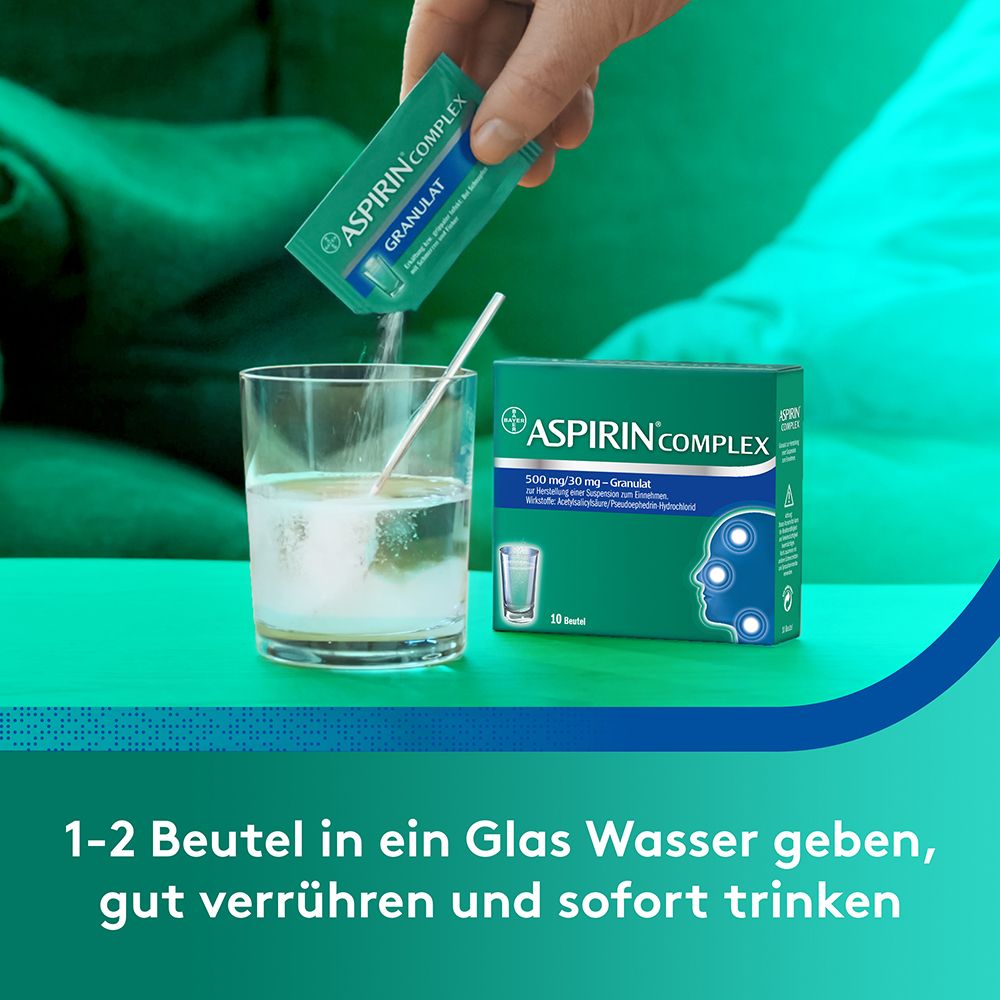 Person gibt Beutel Aspirin Complex in Wasser. Text: 1-2 Beutel in ein Glas Wasser geben, gut verrühren und sofort trinken.