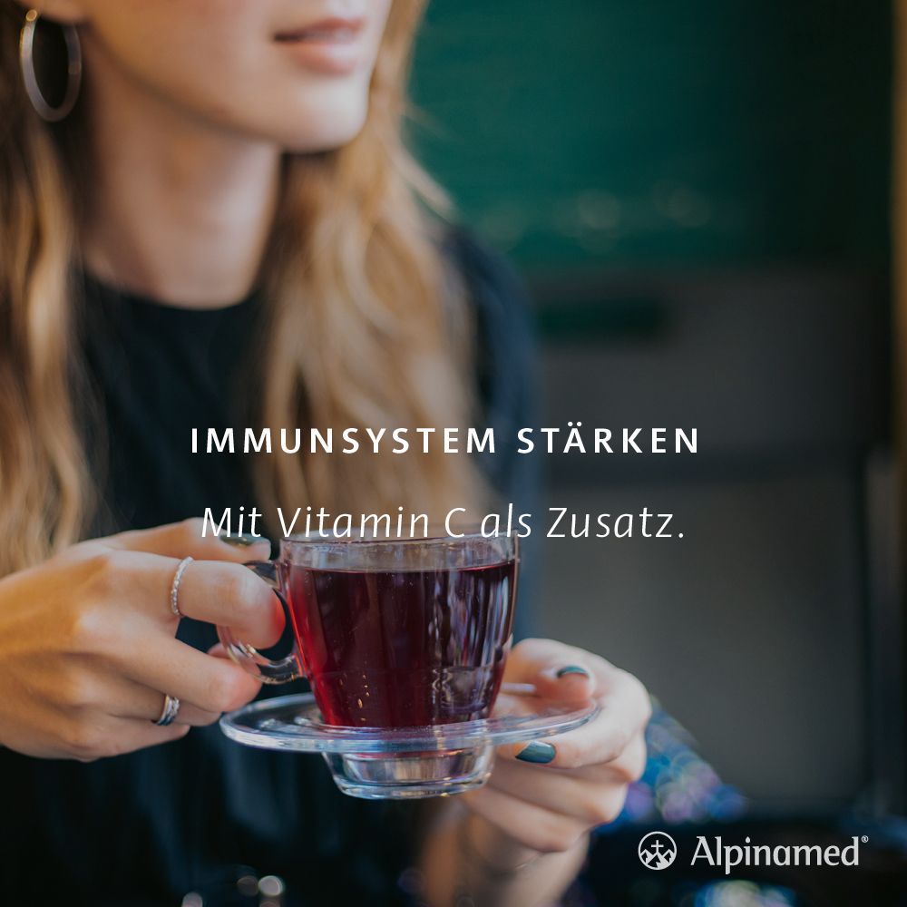Frau mit Tasse Tee. Text: Immunsystem stärken. Mit Vitamin C als Zusatz. Alpinamed Logo.