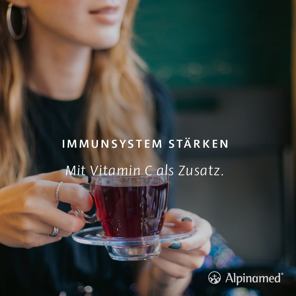 Frau hält eine Tasse. Text: Immunsystem stärken. Mit Vitamin C als Zusatz. Alpinamed Logo.