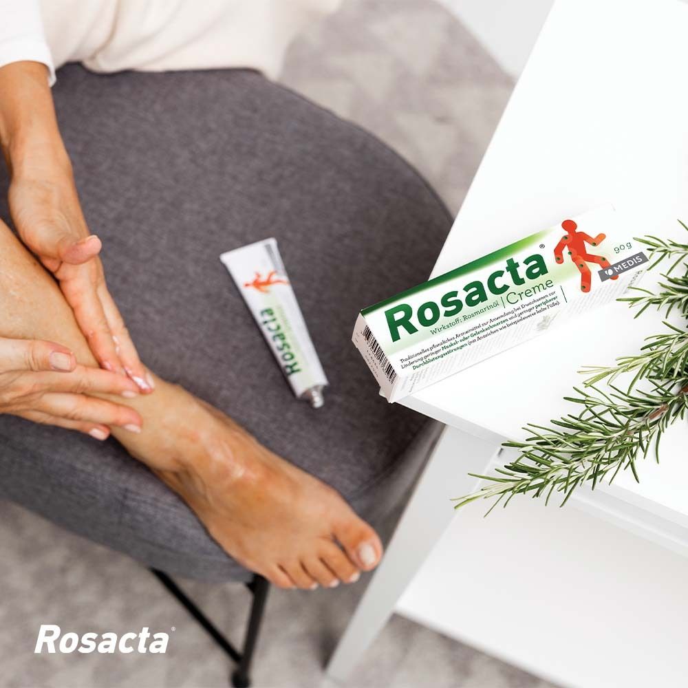 Person gibt Creme auf Fuß. Rosacta Creme Tube und Verpackung. 90g.