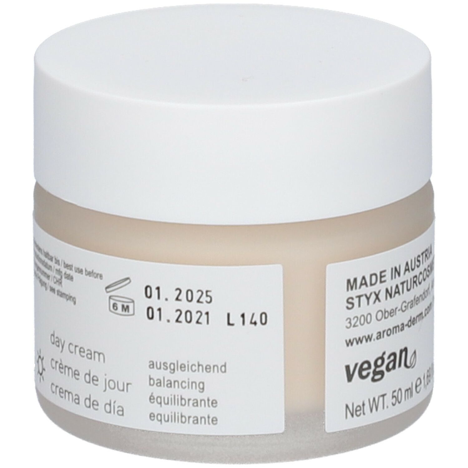 Creme-Tiegel mit weißem Deckel. Aufkleber mit Texten wie 'day cream', 'vegan' und Verfallsdatum.