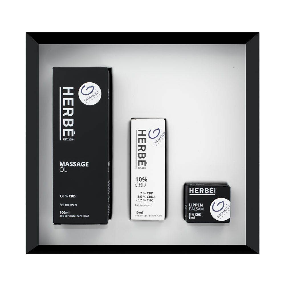 Geöffnete Geschenkbox mit Produkten. Links: Massage Öl. Mitte: 10% CBD. Rechts: Lippenbalsam. HERBÉ-Logo und „Grander France“ Logo.