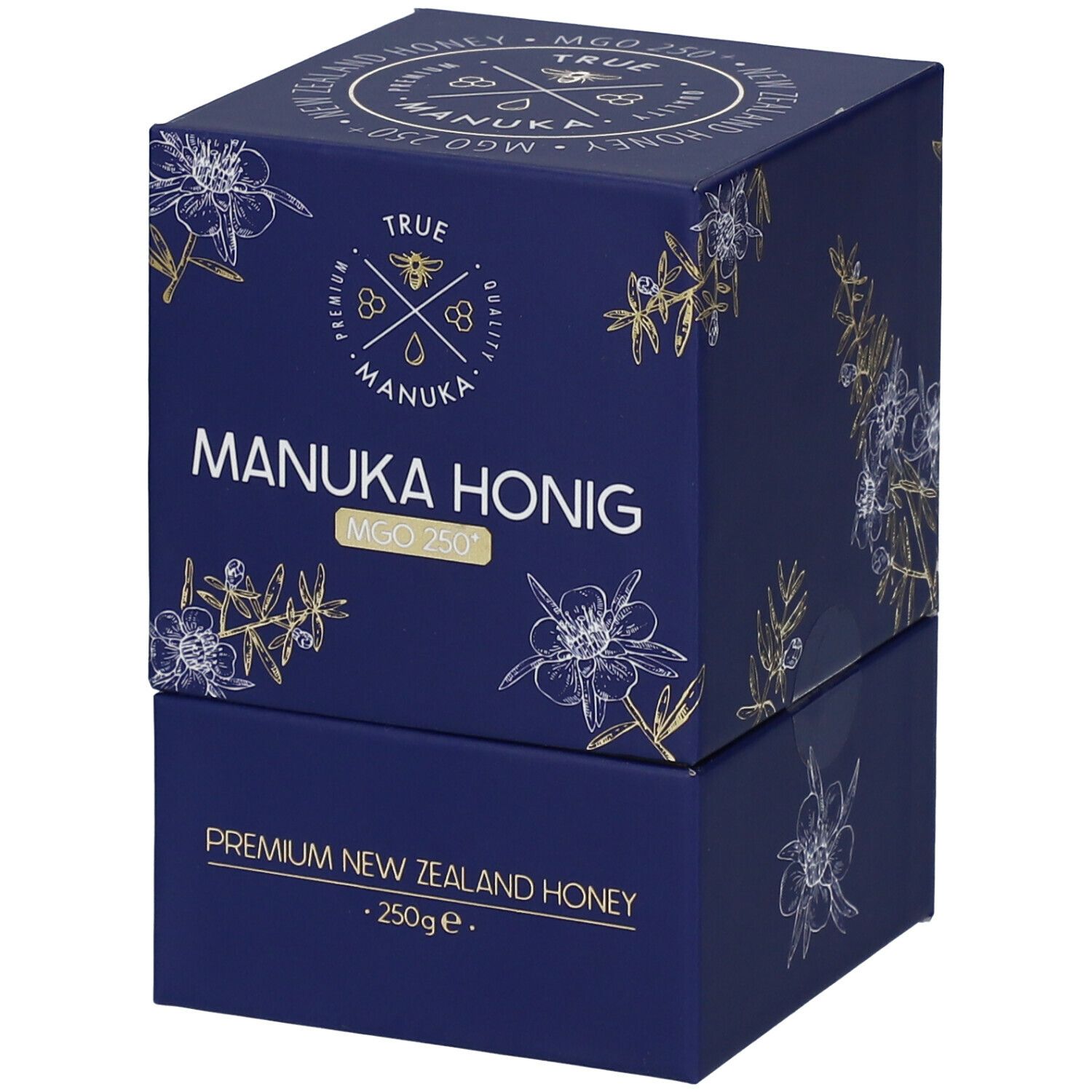 Dunkelblaue Schachtel mit weiß-goldenen floralen Motiven. Aufschrift: "TRUE MANUKA MANUKA HONIG MGO 250+". "Premium New Zealand Honey".