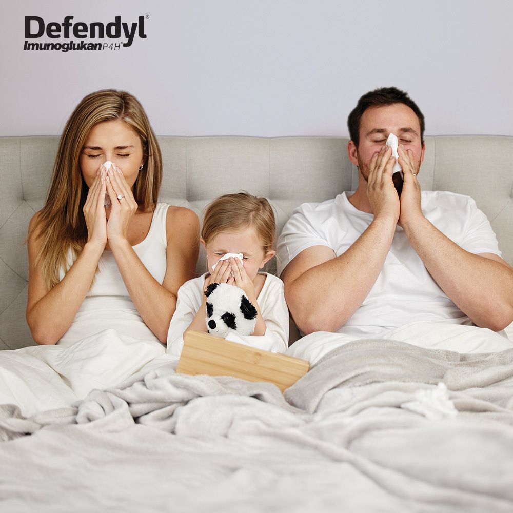 Familie im Bett mit Taschentüchern. Defendyl-Imunoglukan P4H Logo. Erkältungssymptome.