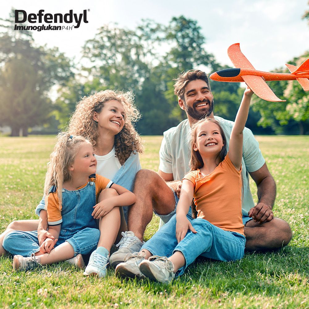 Familie spielt im Freien. Defendyl-Imunoglukan P4H Logo. Kind mit Spielzeug.