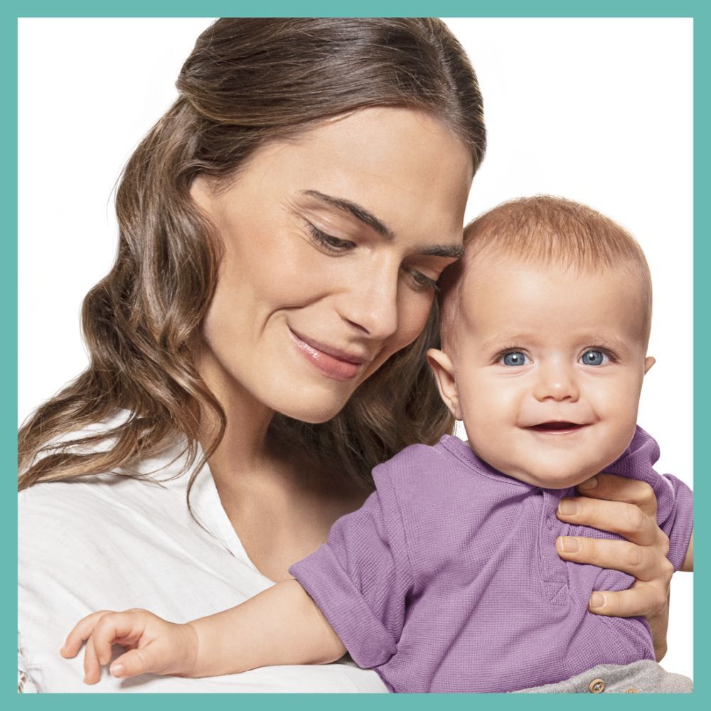 Frau mit Baby. Frau lächelt, Baby schaut in die Kamera. Baby trägt ein lila Shirt.