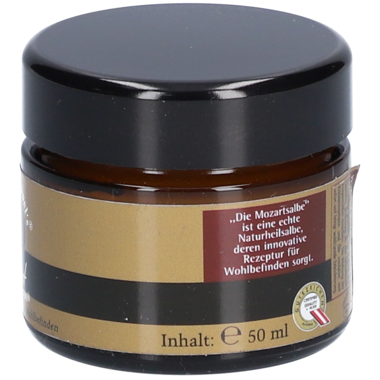 Brauner Salbentiegel mit schwarzem Deckel. Aufschrift: „Die Mozartsalbe“ ist eine echte Naturheilsalbe. Inhalt: 50 ml.