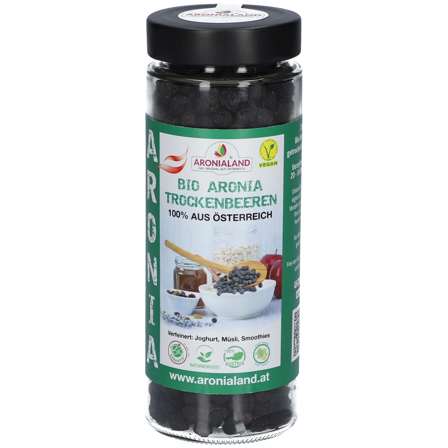 Glas mit getrockneten Aronia-Beeren. Grün-weißes Etikett mit Produktname, Logo und Illustrationen. Schwarzer Deckel.