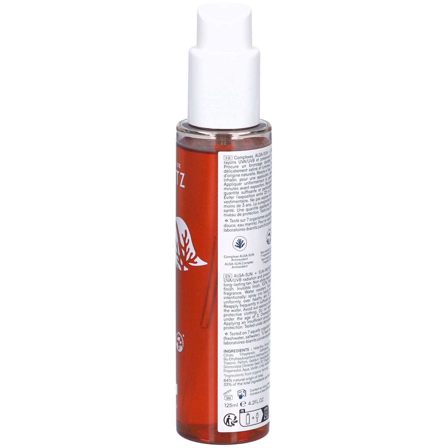 Rückseite des Sonnenschutzöls. Text auf Etikett. Flasche mit weißem Pumpkopf. Rote Flüssigkeit sichtbar. Informationen über Inhaltsstoffe.