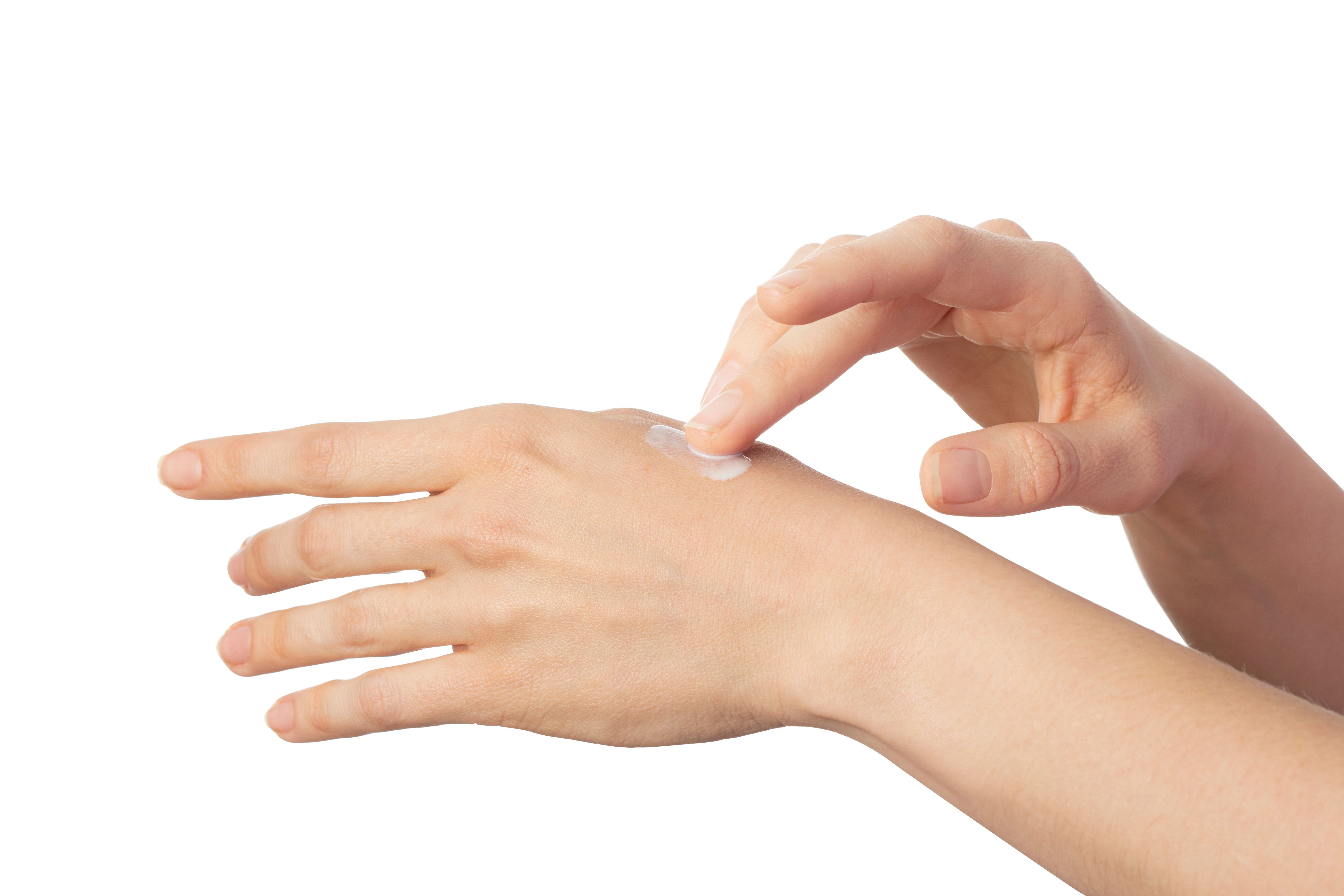 Hand, die Creme auf der Haut verreibt. Creme auf der Haut.