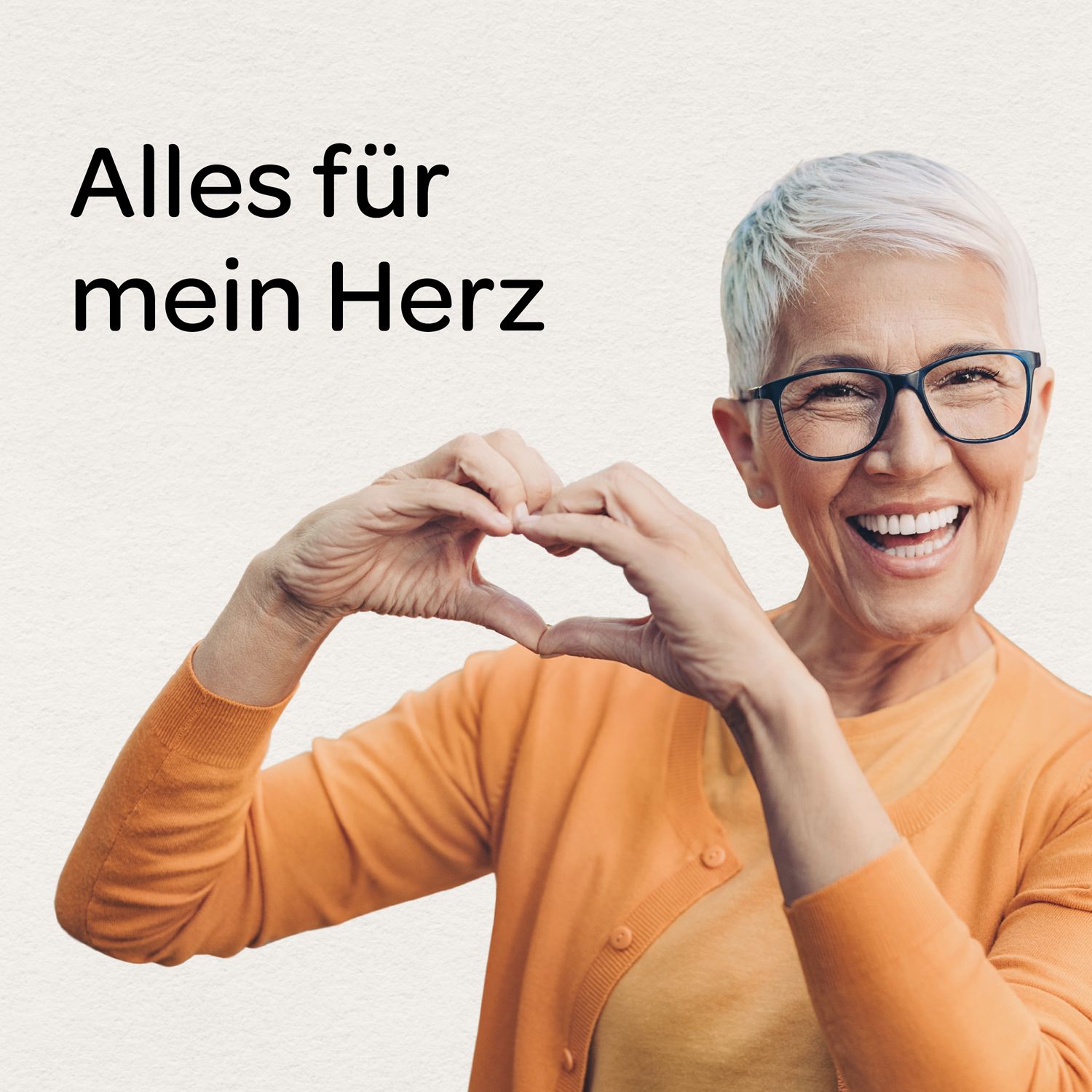 Ältere Frau formt mit Händen Herz. Sie trägt Brille und orangefarbene Jacke. Text: Alles für mein Herz.
