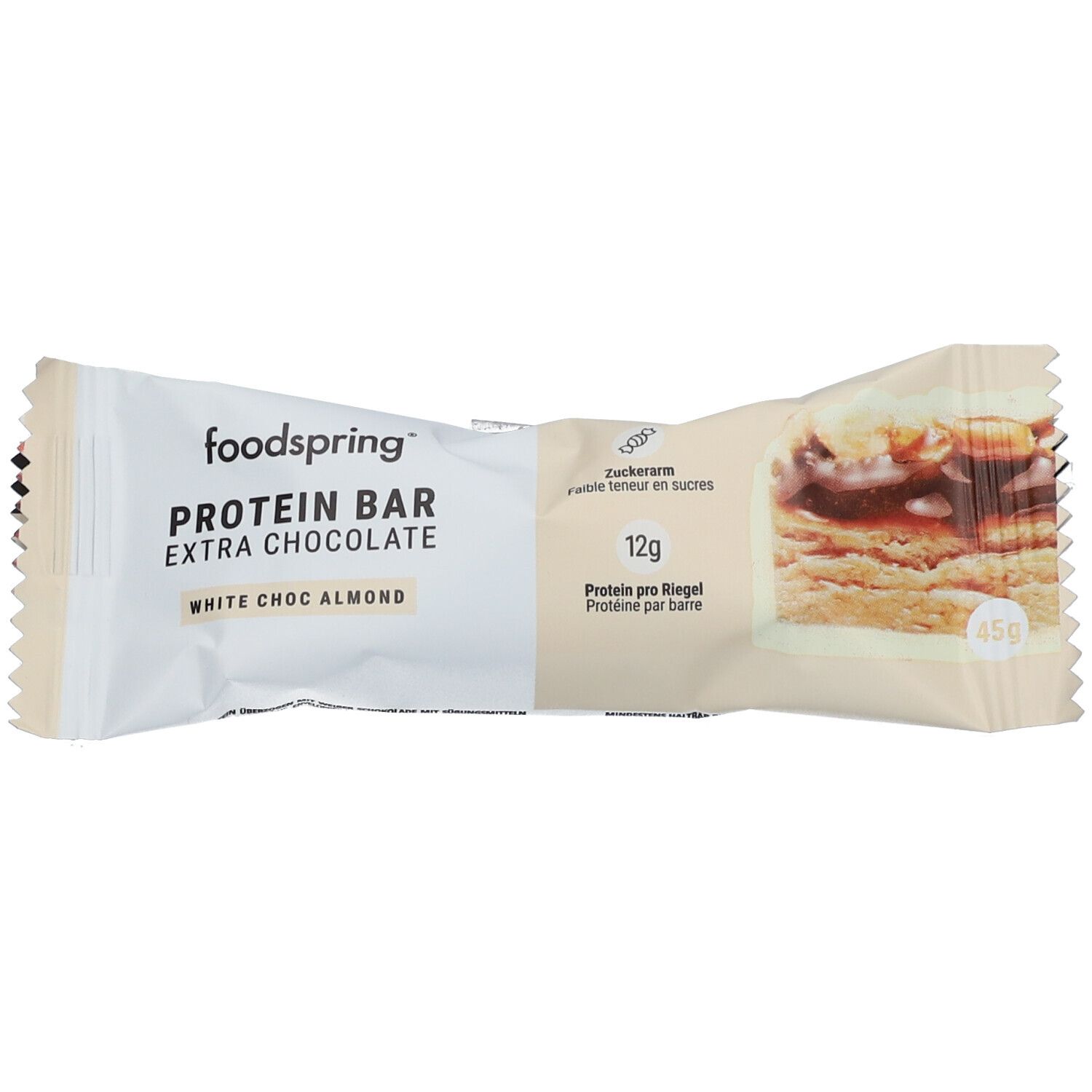 Proteinriegel in weißer Verpackung. Aufschrift: foodspring PROTEIN BAR EXTRA CHOCOLATE WHITE CHOC ALMOND. 12g Protein pro Riegel. 45g.