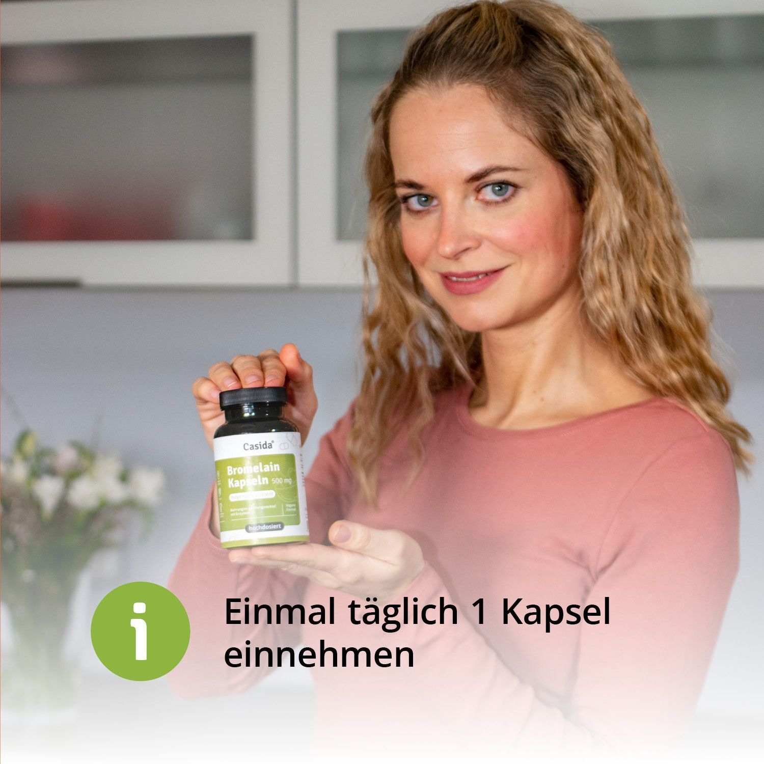 Frau hält eine Flasche Casida® Bromelain Kapseln 500 mg. Aufschrift: Bromelain Kapseln 500 mg. Text: Einmal täglich 1 Kapsel einnehmen.