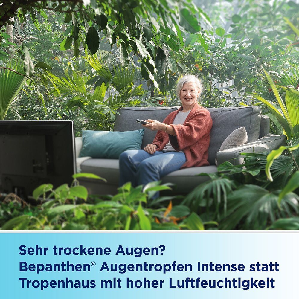 Ältere Frau entspannt sich in einem üppigen Garten vor einem Fernseher.