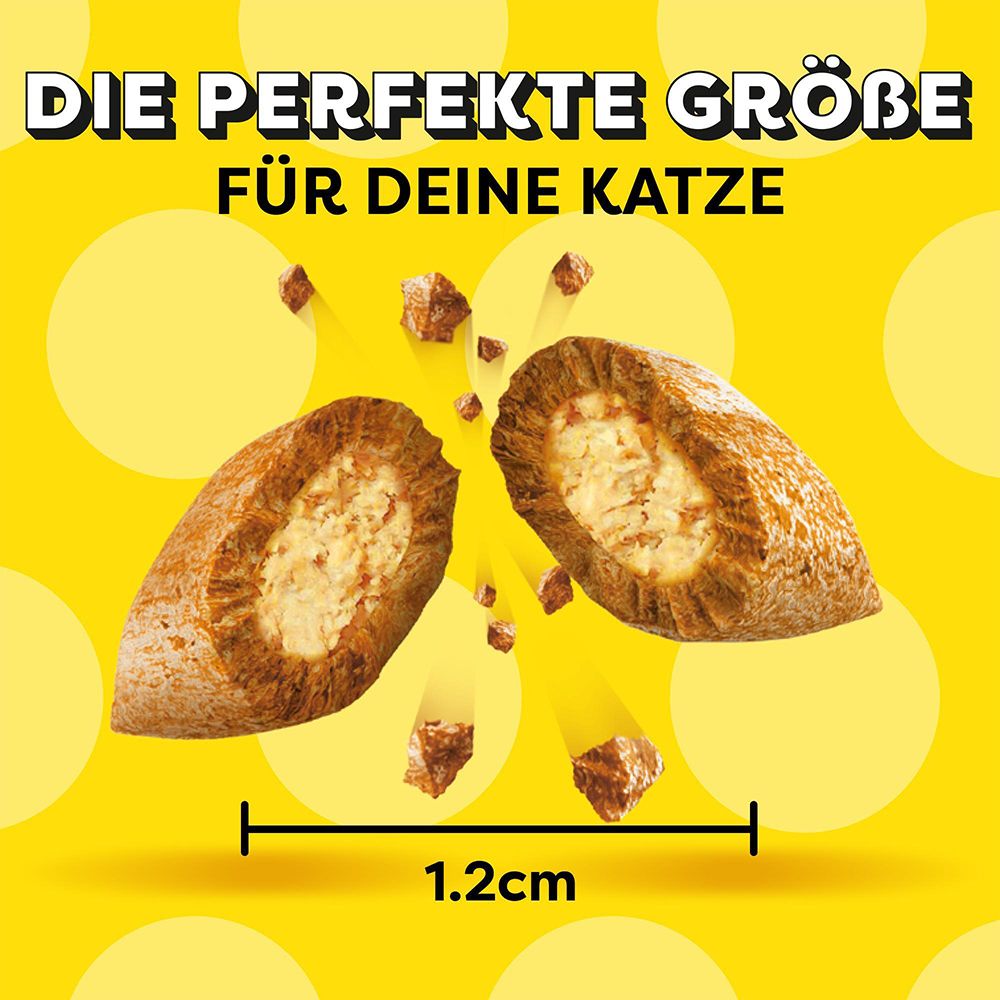 Zwei Dreamies Leckerli, 1,2 cm groß, auf gelbem Hintergrund.