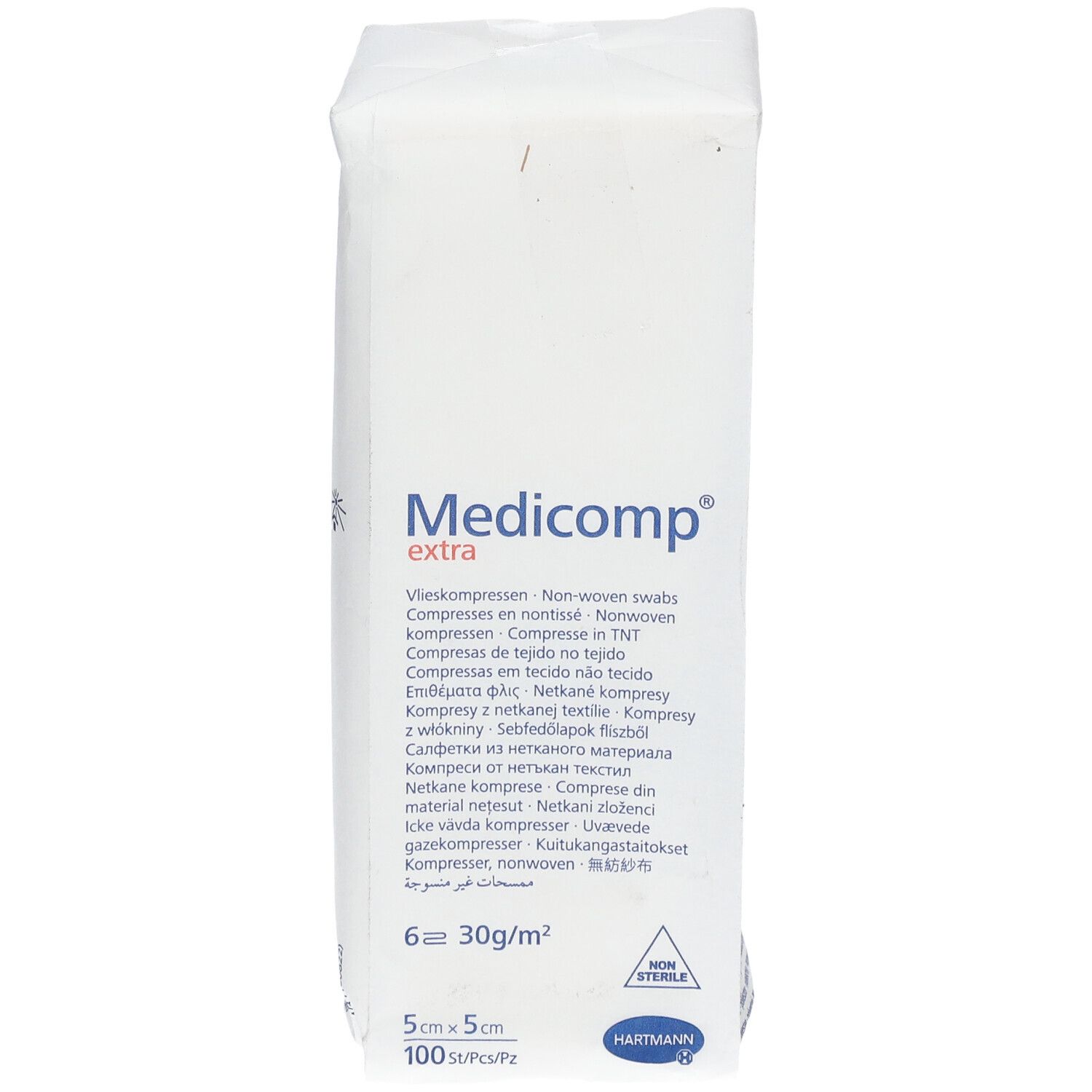 Verpakking met witte kompressen. Opschrift: Medicomp extra, 5x5cm, 100 stuks. Fabrikant: HARTMANN. Steriel.