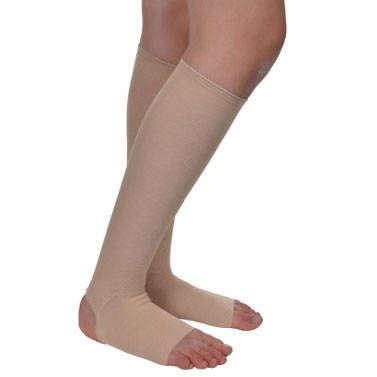 Bas de compression beiges sur une jambe. Bout ouvert, s'étendant jusqu'au genou.