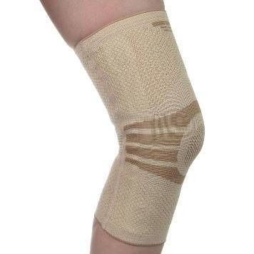 Genouillère beige sur une jambe. Tricot, renforts au niveau du genou. Taille 2.