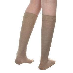 Beige kniekousen. Zicht van onderaf op twee benen die kousen dragen. De kousen komen tot onder de knie.