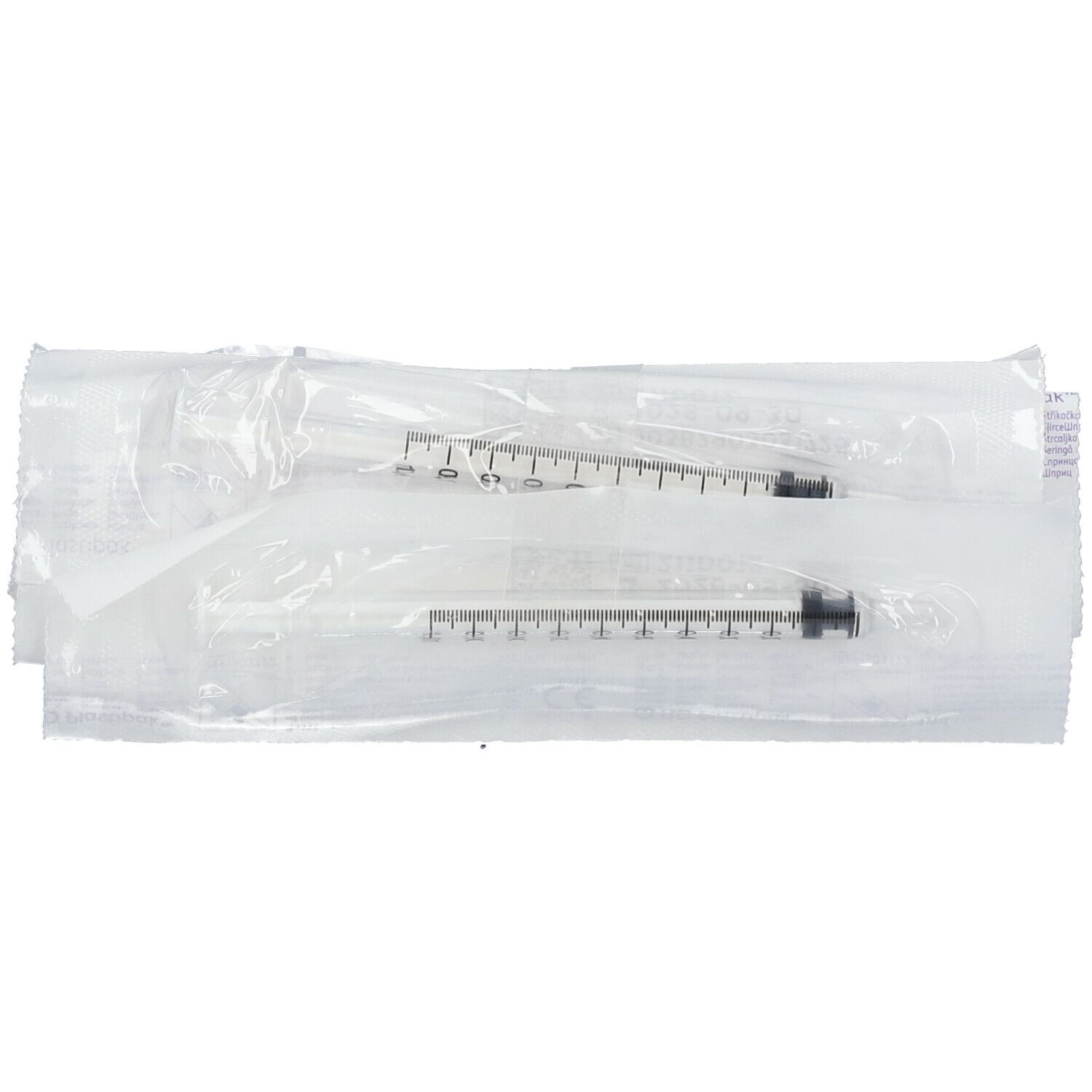Deux seringues stériles emballées individuellement. Cylindres en plastique transparent avec pistons noirs. Graduations visibles.