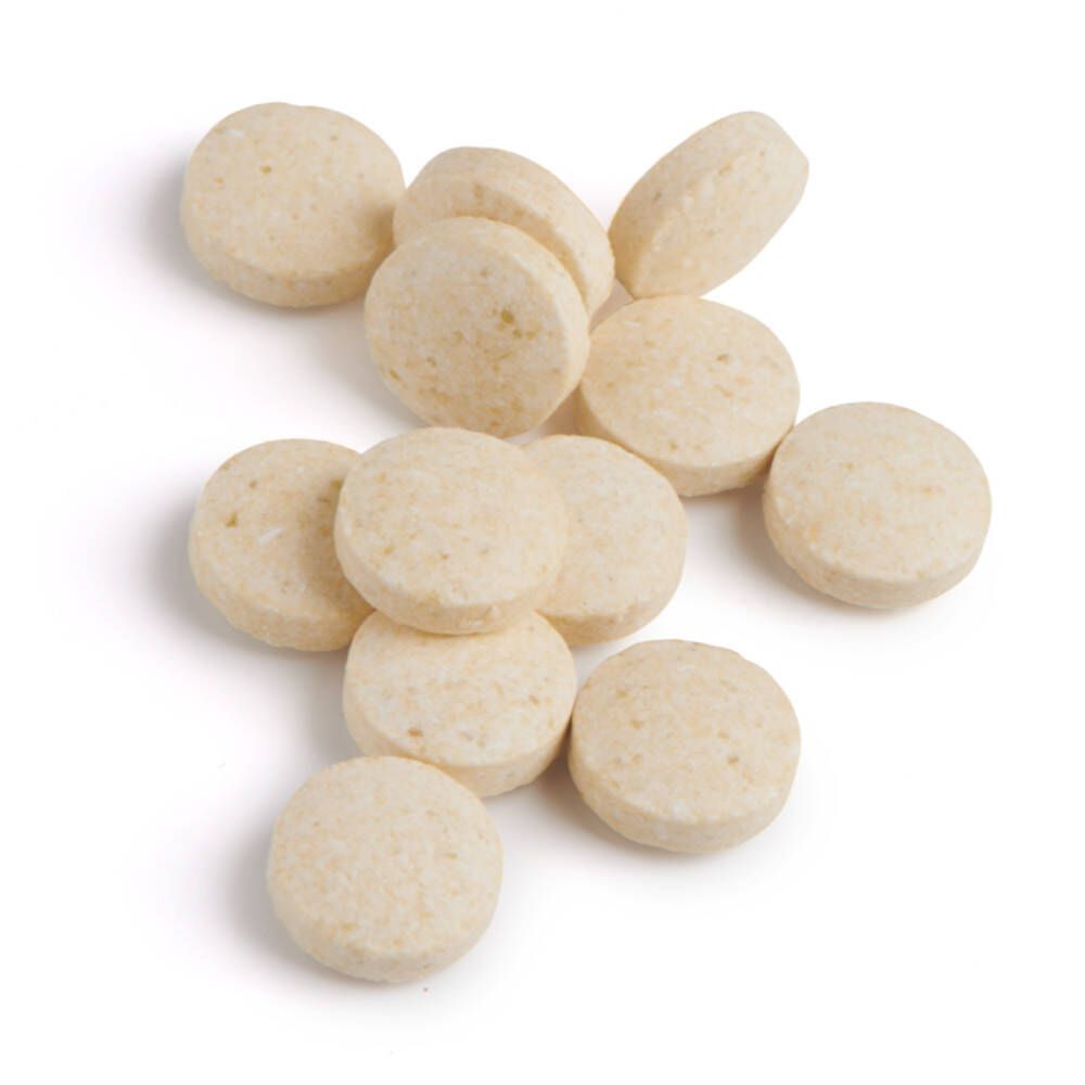 Stapel lichtgele, ronde tabletten. Geen verpakking zichtbaar.
