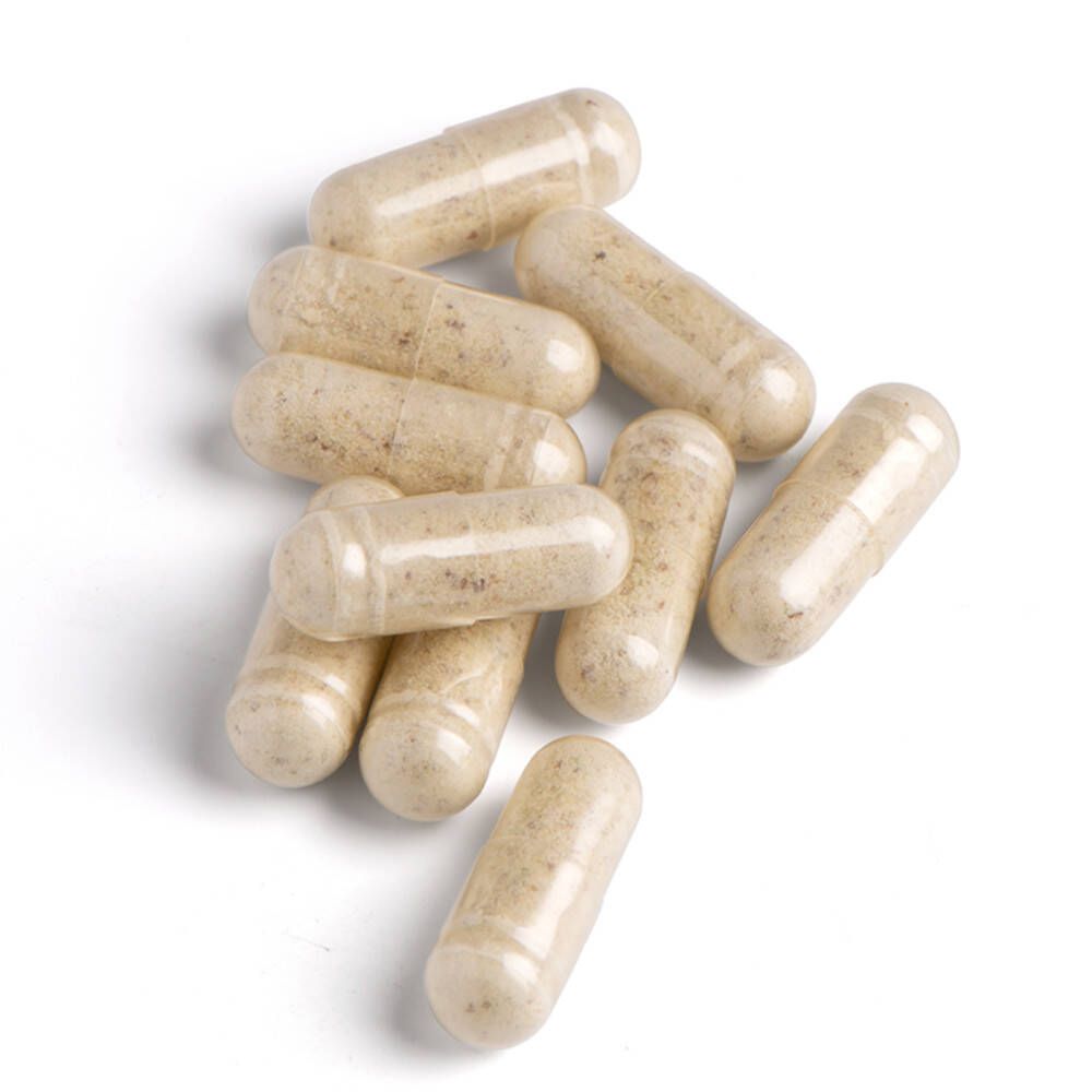 Tien beige capsules op een witte achtergrond. Capsules zijn langwerpig en doorschijnend.