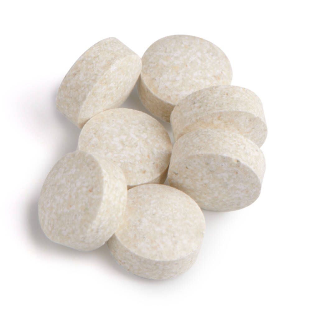 Acht ronde, beige tabletten. Geen opschrift zichtbaar.