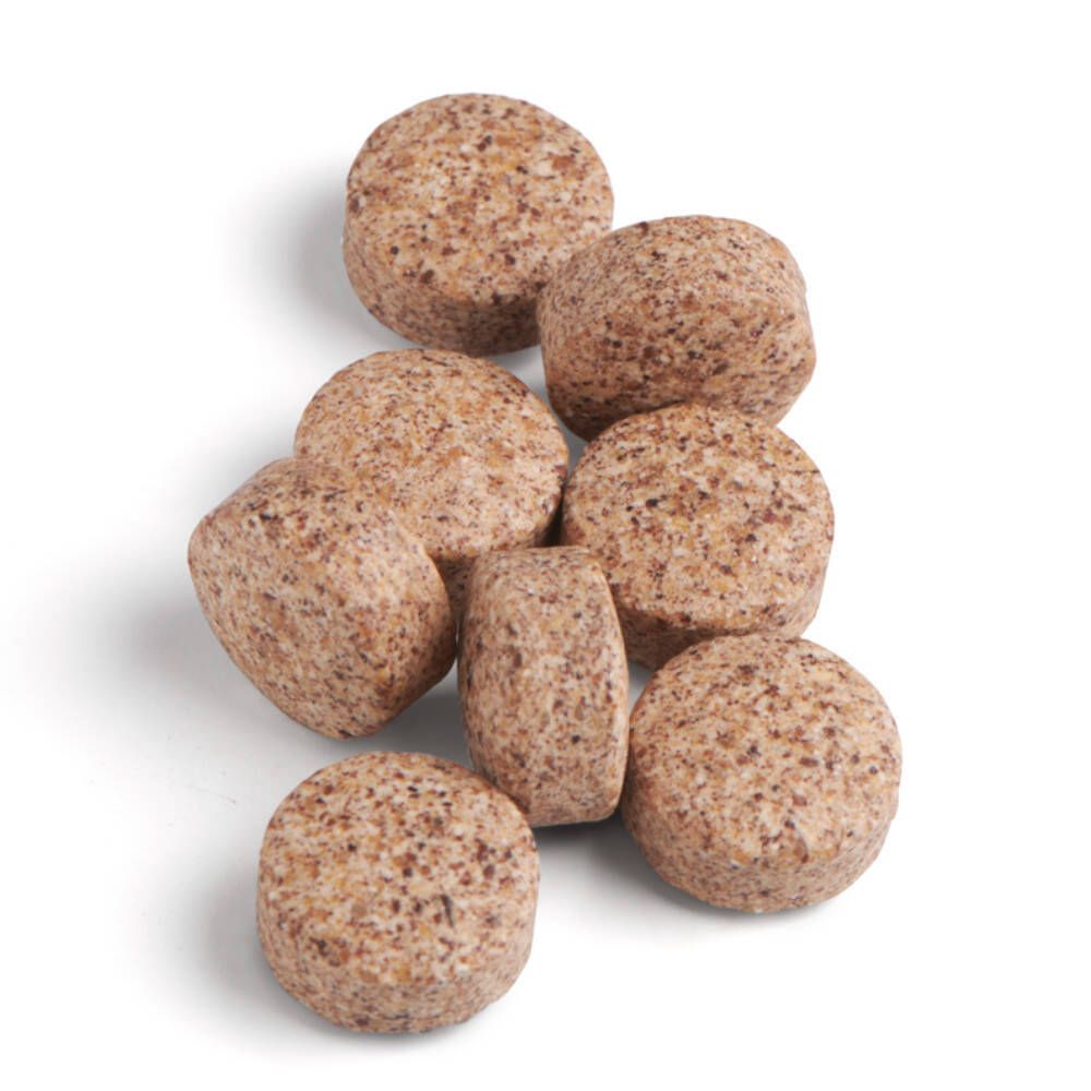 Tabletten, braun und rundlich. Mehrere Tabletten liegen auf weißem Hintergrund.