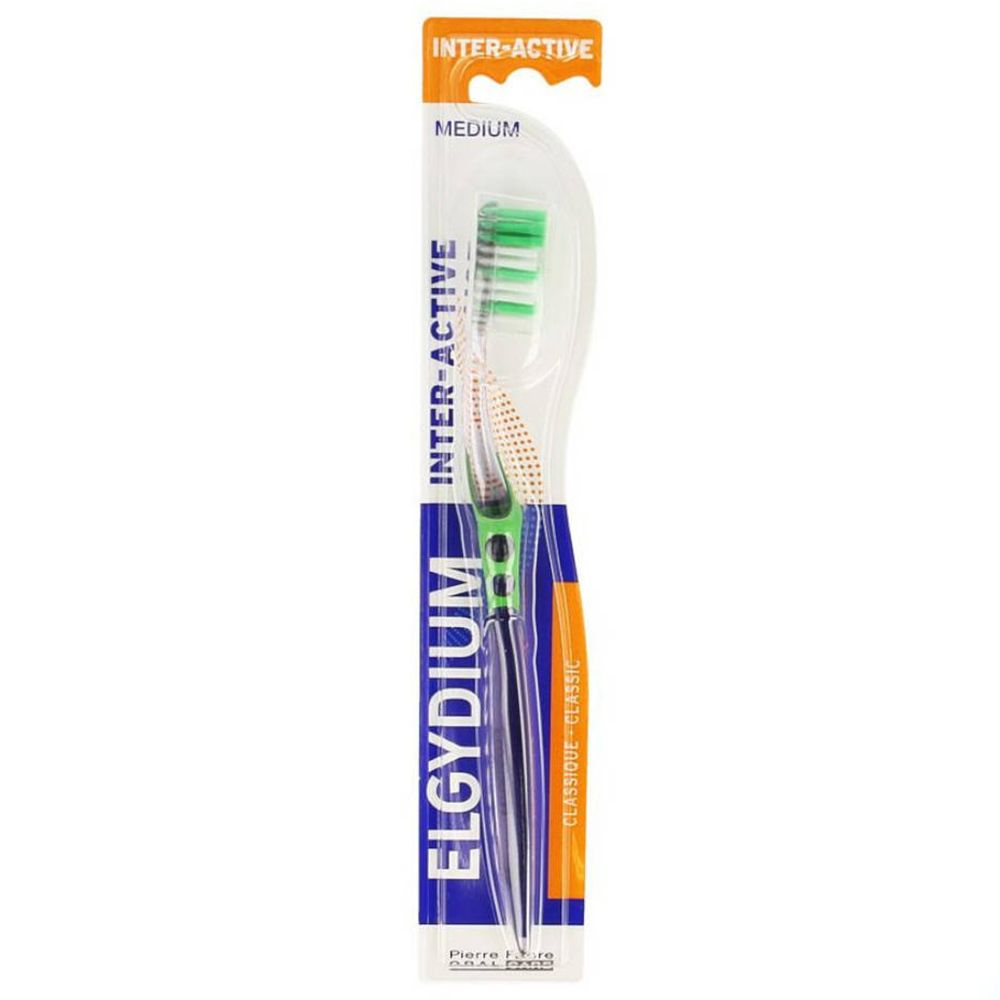Brosse à dents avec poils verts et blancs, emballée dans un blister transparent. Inscription : ELGYDIUM INTER-ACTIVE MEDIUM.