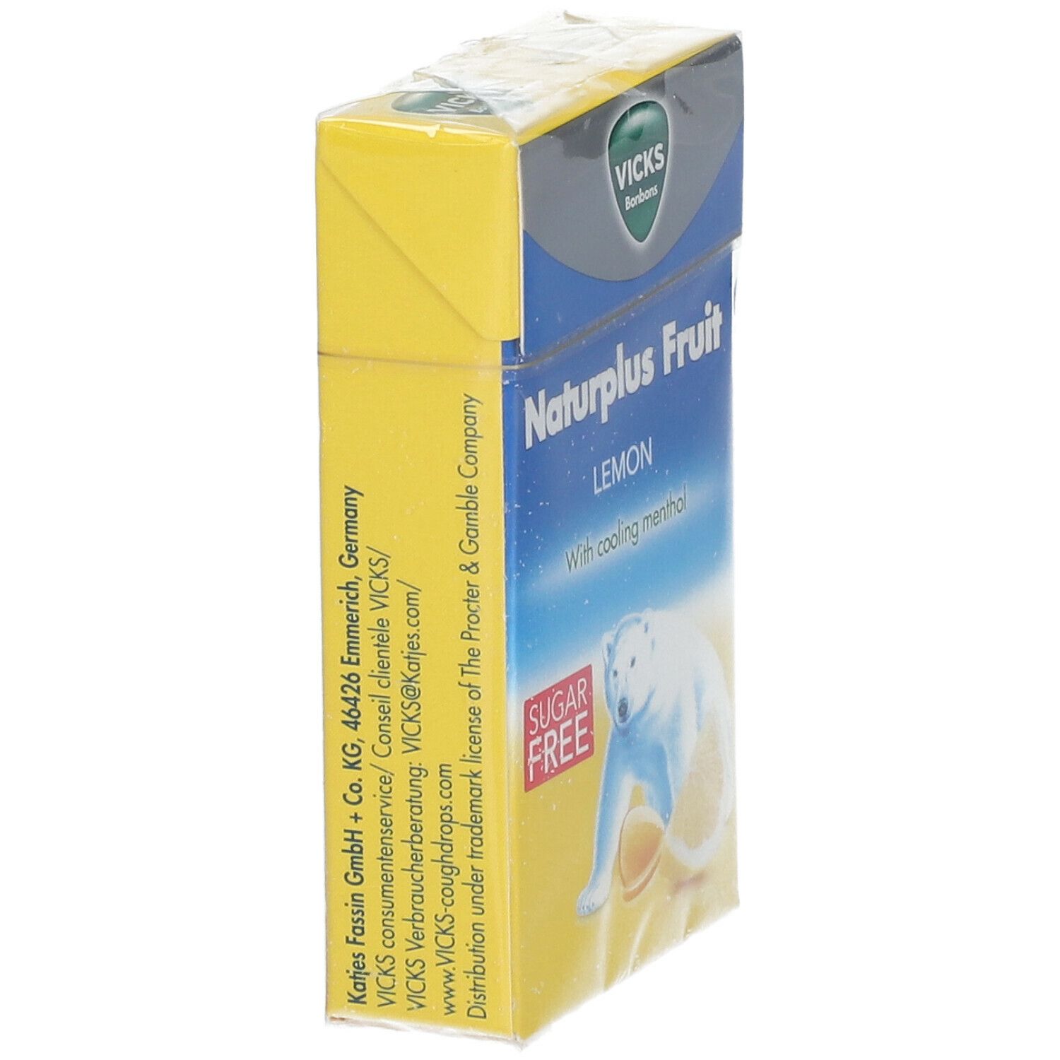Boîte jaune Vicks Naturplus Fruit. Inscription: Citron, sans sucre, ours polaire. Texte et logo sur le côté. En film.