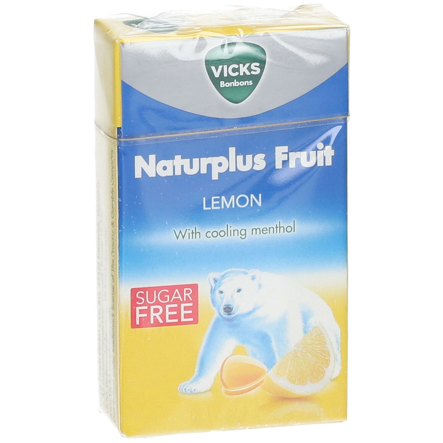 Face avant de la boîte jaune Vicks Naturplus Fruit. Inscription: Citron, sans sucre, ours polaire. En film.