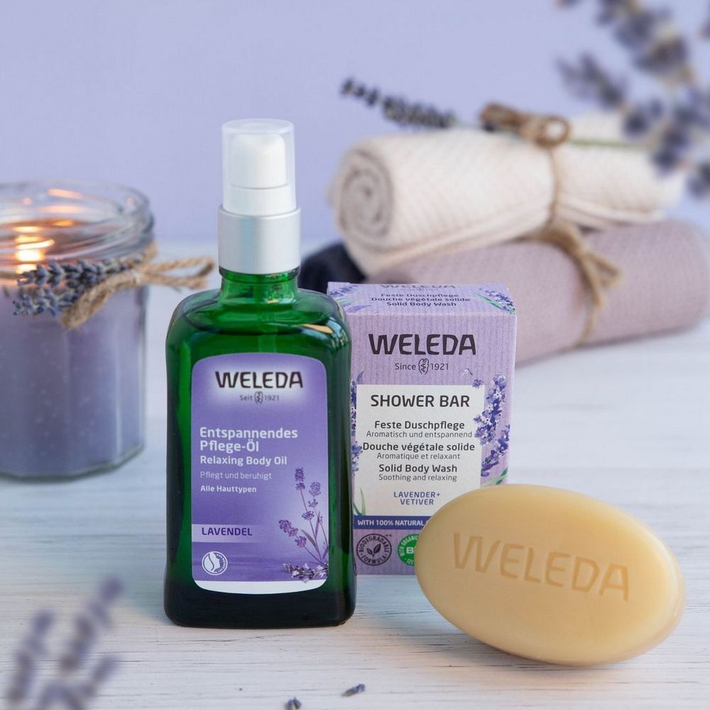 Flacon vert, savon et pain de savon. Texte: 'WELEDA'. 'Huile de soin relaxante'.