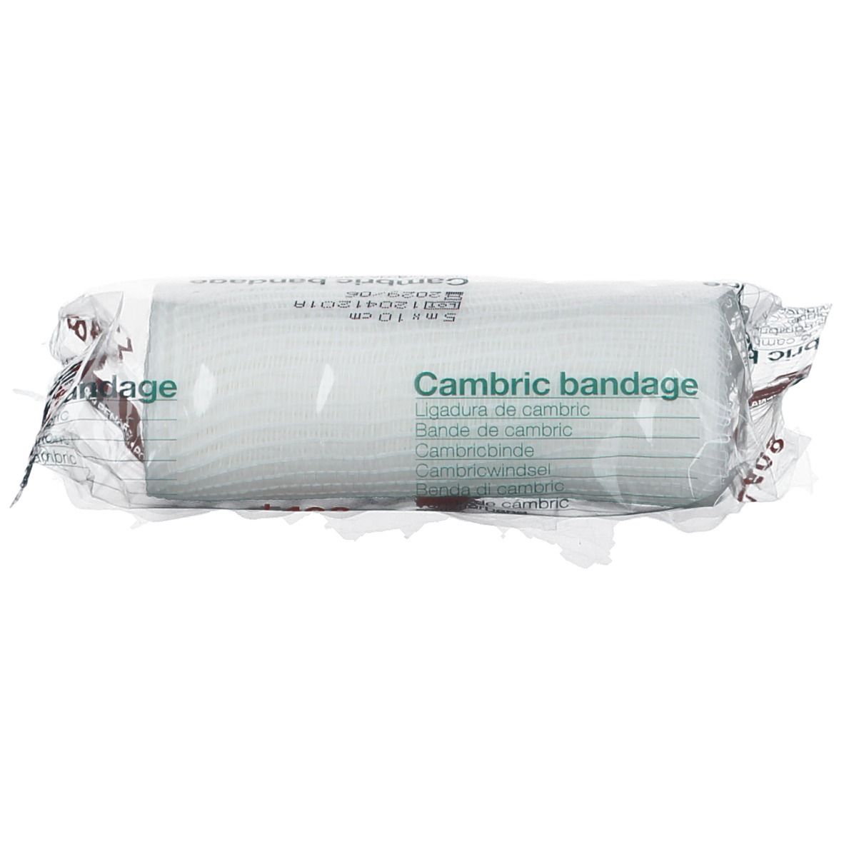 Rouleau de bandage en emballage plastique. Inscription : Cambric bandage. Matériau de bandage blanc visible. Texte multilingue.