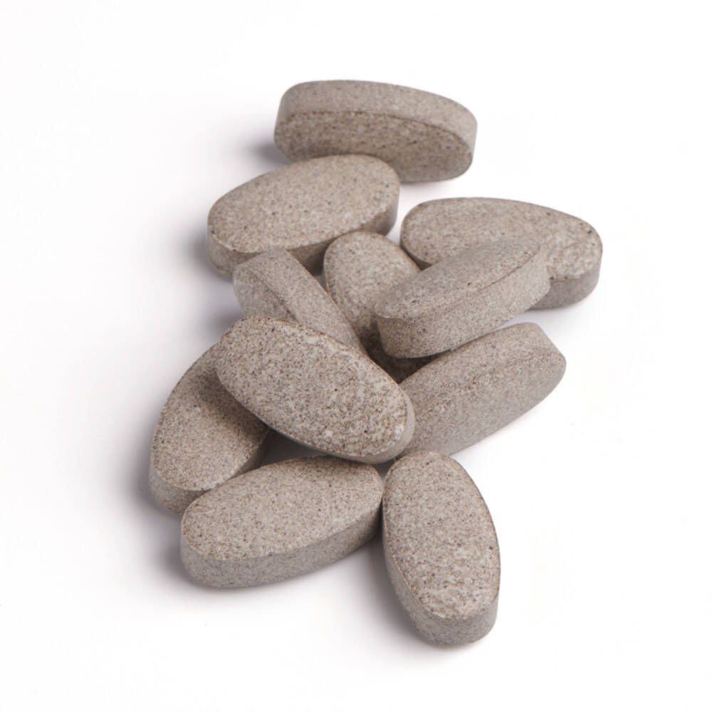 Stapel ovale, beige tabletten. Geen verpakking zichtbaar.