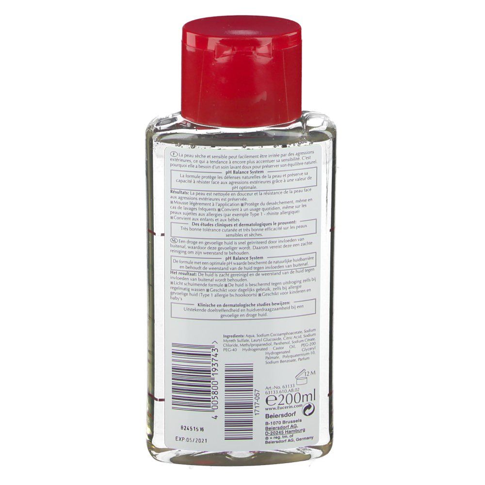 Dos d'un flacon transparent avec bouchon rouge. Informations textuelles et code-barres. Peaux sèches et sensibles.