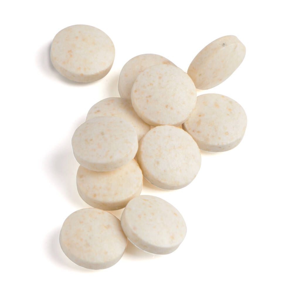 Stapel ronde, beige tabletten. Geen opschrift zichtbaar.