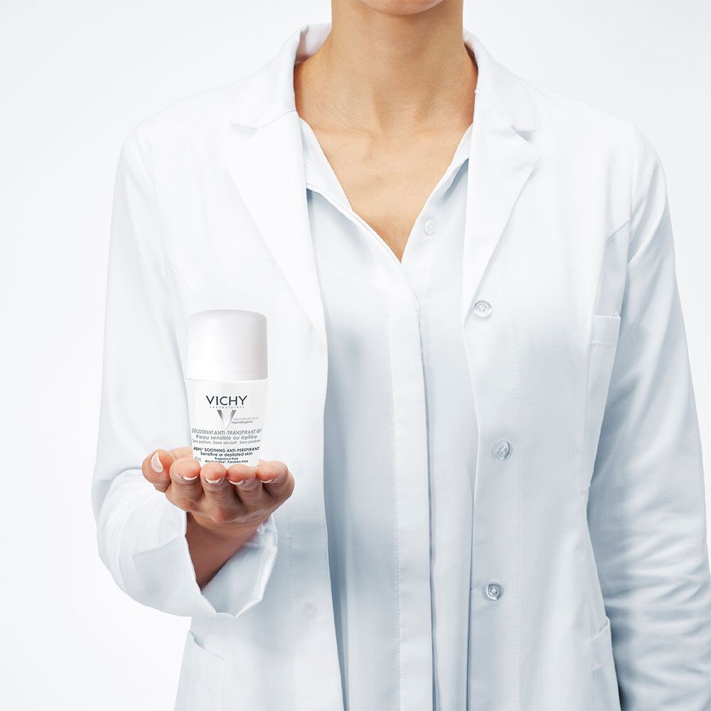 Persoon houdt een witte VICHY roll-on deodorant in de hand. Persoon draagt een witte laboratoriumjas.