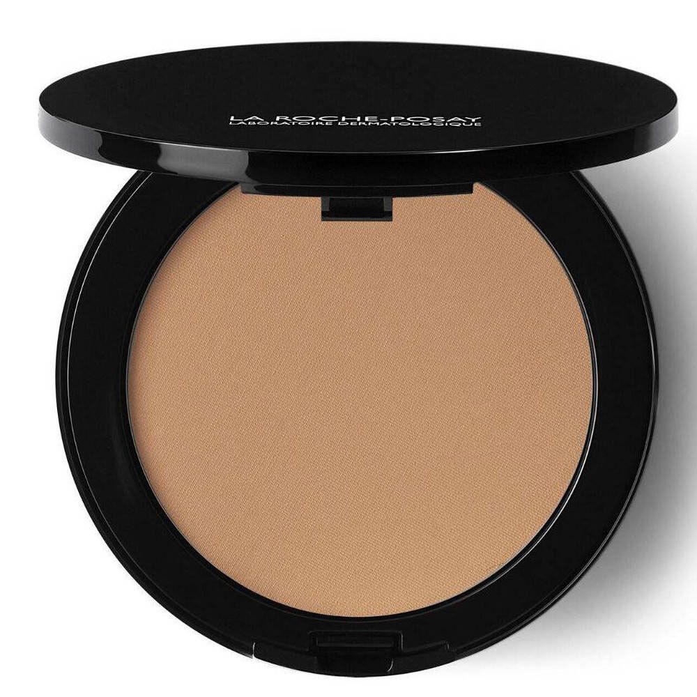 Poudre compacte de maquillage ronde noire, couvercle ouvert. La poudre est brun clair.