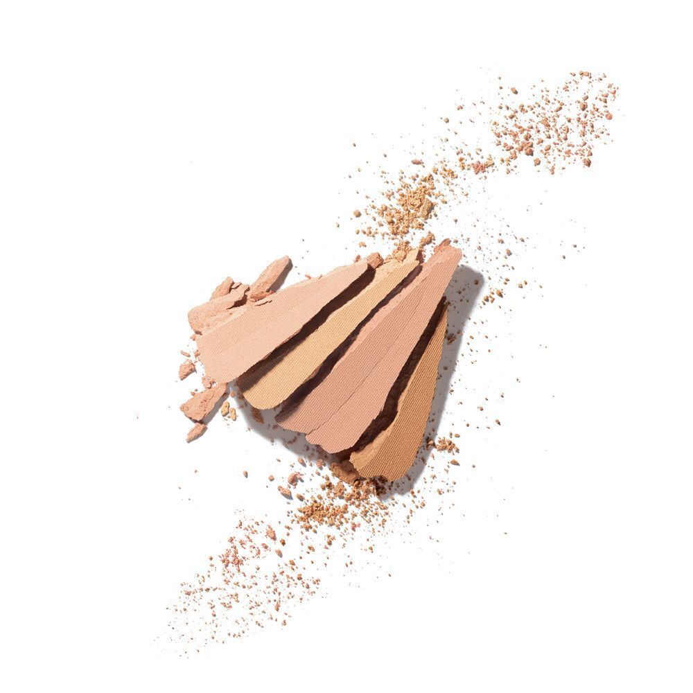 Différentes teintes de poudre de maquillage sur fond blanc. Certaines poudres sont cassées.