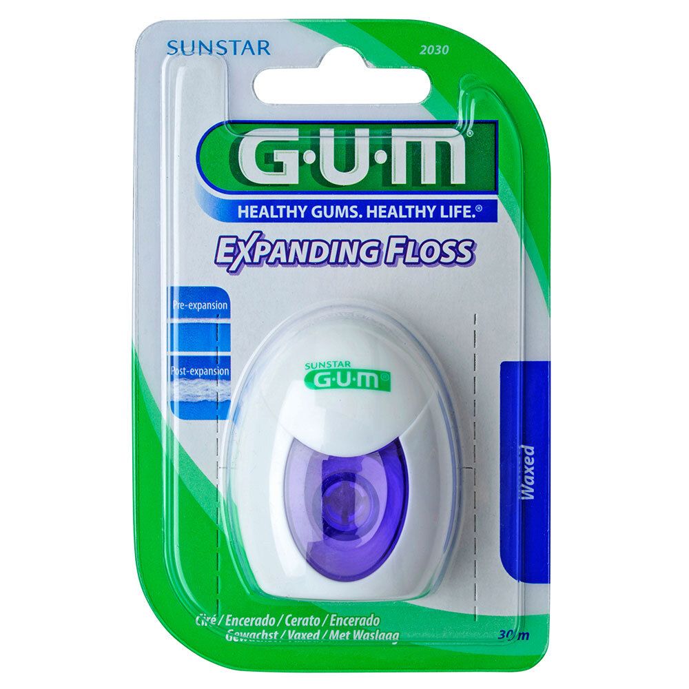 Tandflosdispenser in blisterverpakking. Witte behuizing met paarse inzet. Opschrift: GUM Expanding Floss. Groene verpakking met merklogo.