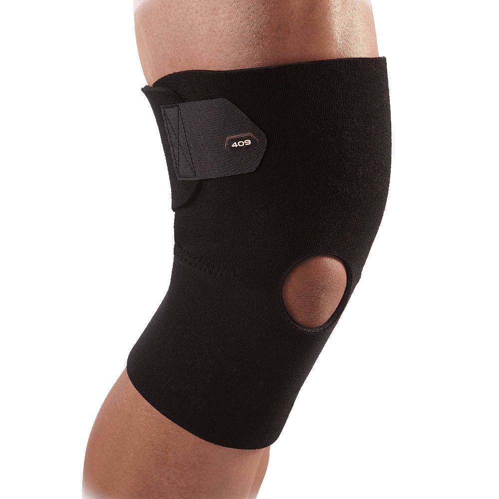 Genouillère noire à rotule ouverte. Fermeture velcro réglable. Marque 409.