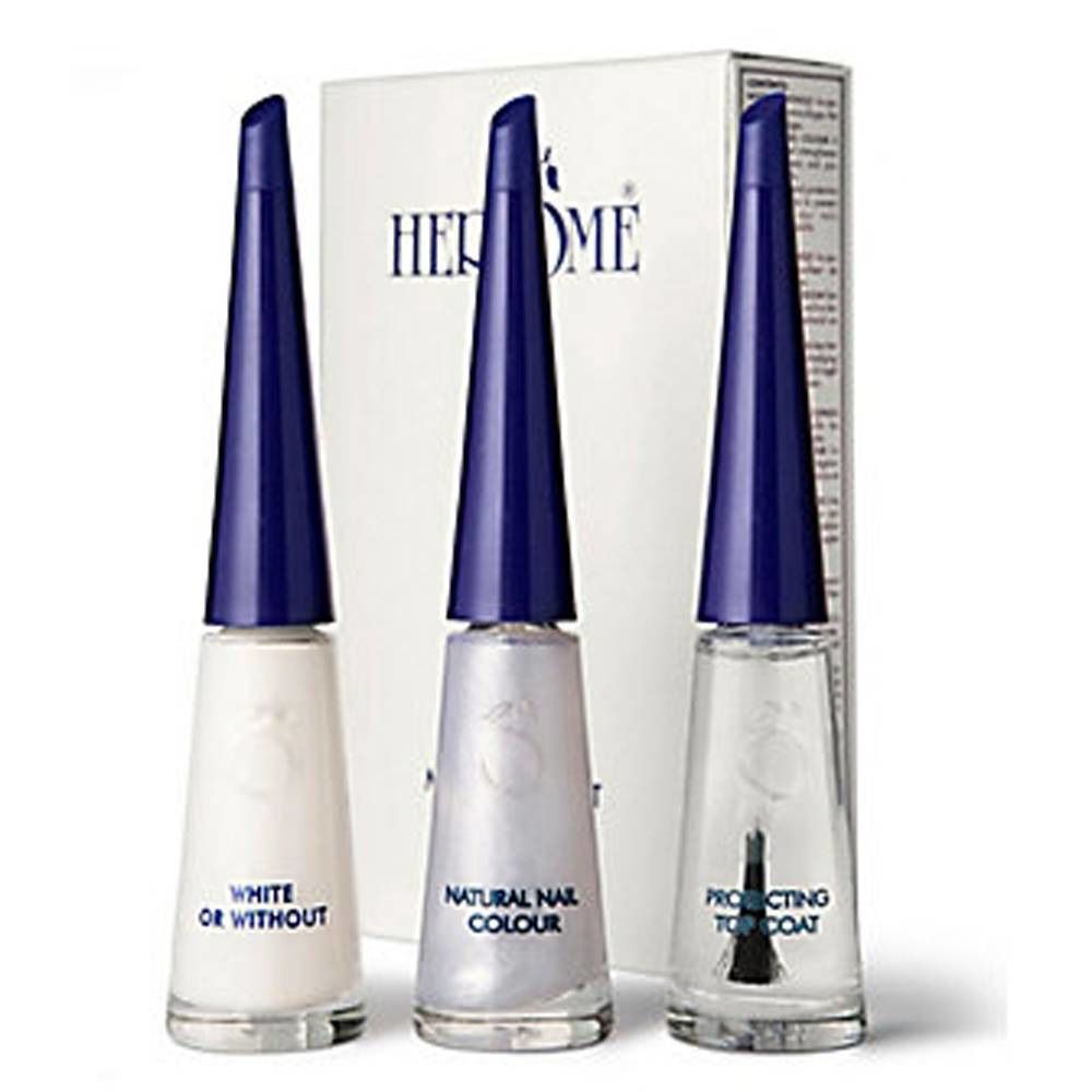 Drie nagellakflesjes met blauwe doppen. Op de verpakking staat HERÔME. Op de flesjes staat: White, Natural Nail Colour, Protecting Top Coat.