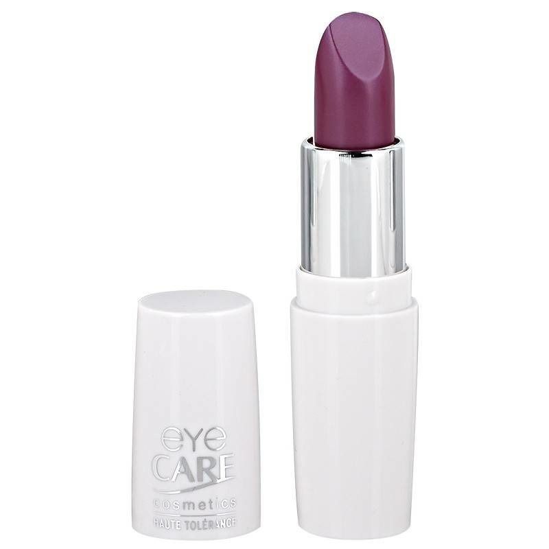 Paarse lipstick. Witte, cilindrische houder met zilveren ring. Dop ernaast. Opschrift EYE CARE.