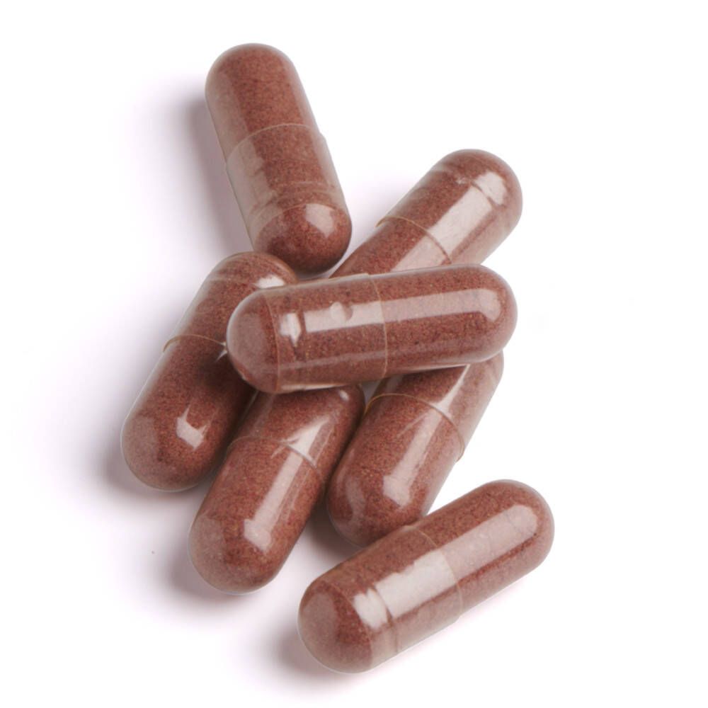 Sette capsule marroni su sfondo bianco. Le capsule sono oblunghe e trasparenti.
