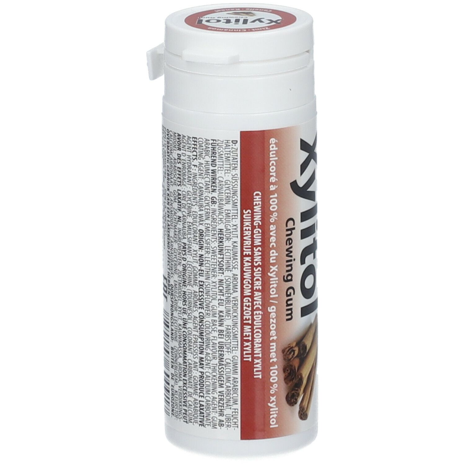 Contenant blanc avec étiquette rouge. Inscription: Xylitol Chewing Gum. Texte multilingue. Image de bâtons de cannelle.
