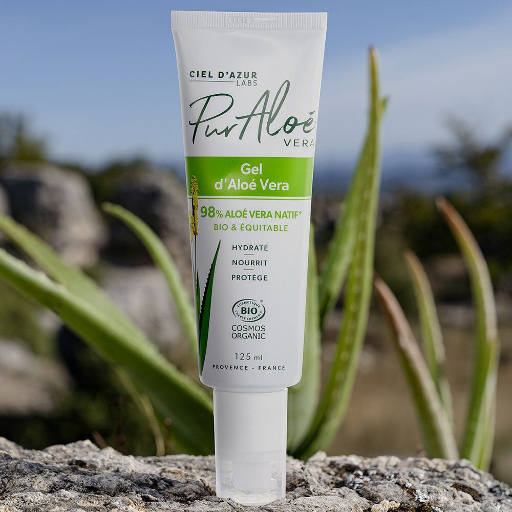 Tube blanc avec impression verte, devant des plantes et des pierres. Texte : PurAloé Vera Gel d'Aloé Vera. Certification bio.