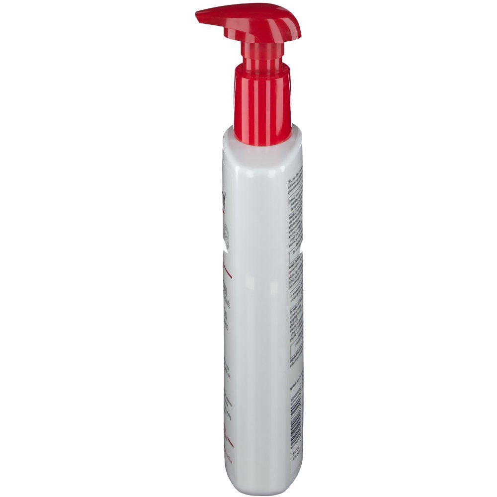 Flacon blanc avec pompe rouge, vue latérale. Texte sur le flacon.