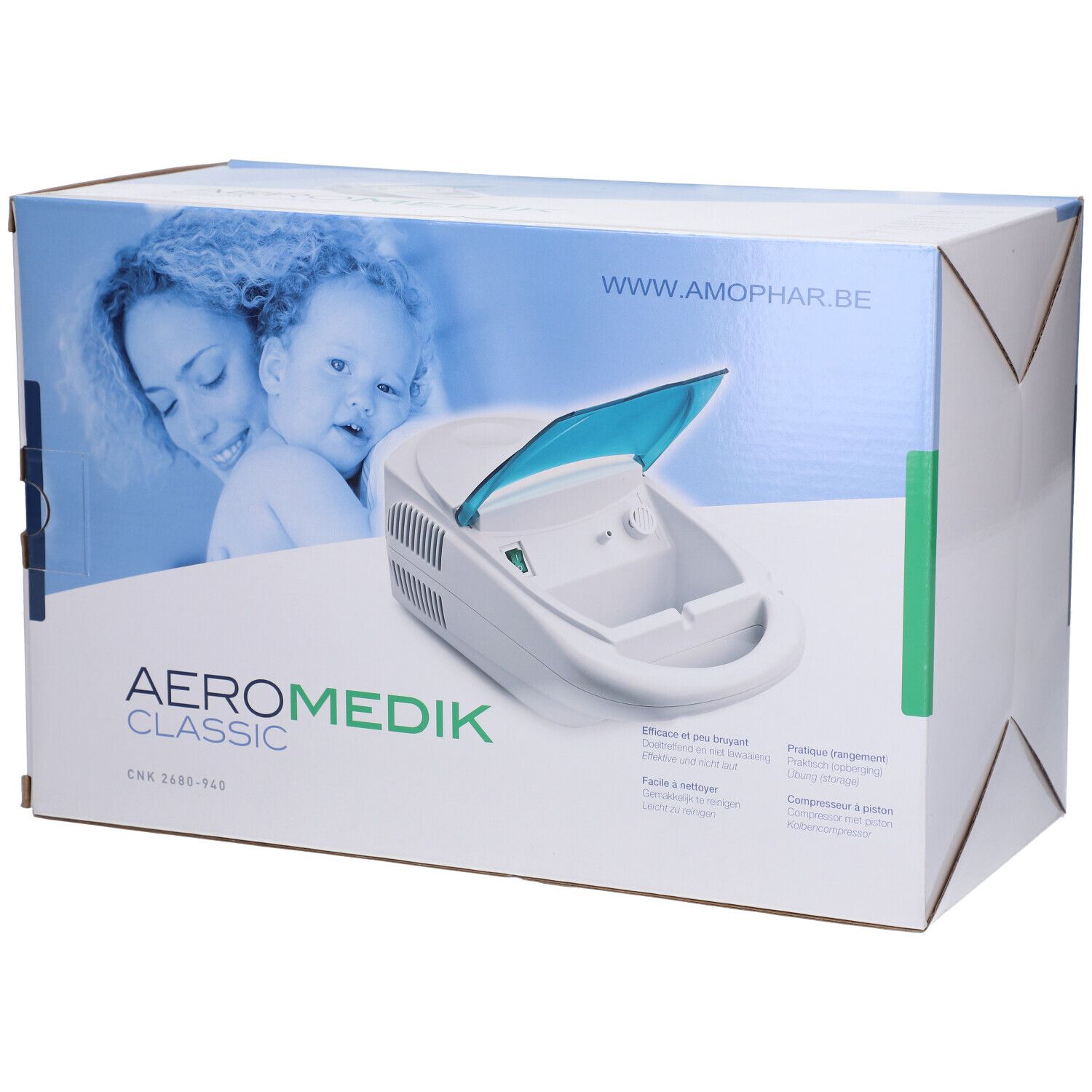 Aérosol Medik Classic dans son emballage. Appareil blanc avec couvercle bleu. Inscription: AERO MEDIK CLASSIC. Adresse du site web.